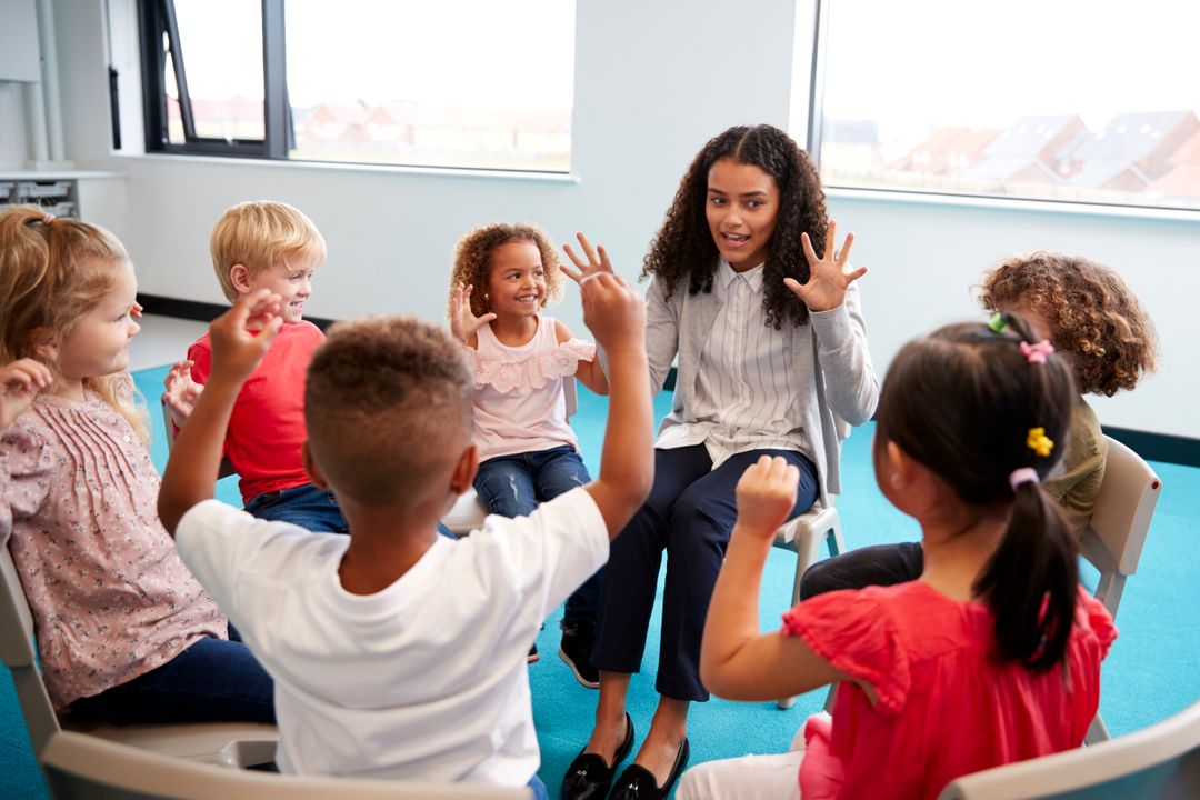 a-class-of-infant-school-children-sitting-on-chair-9LPUBHN